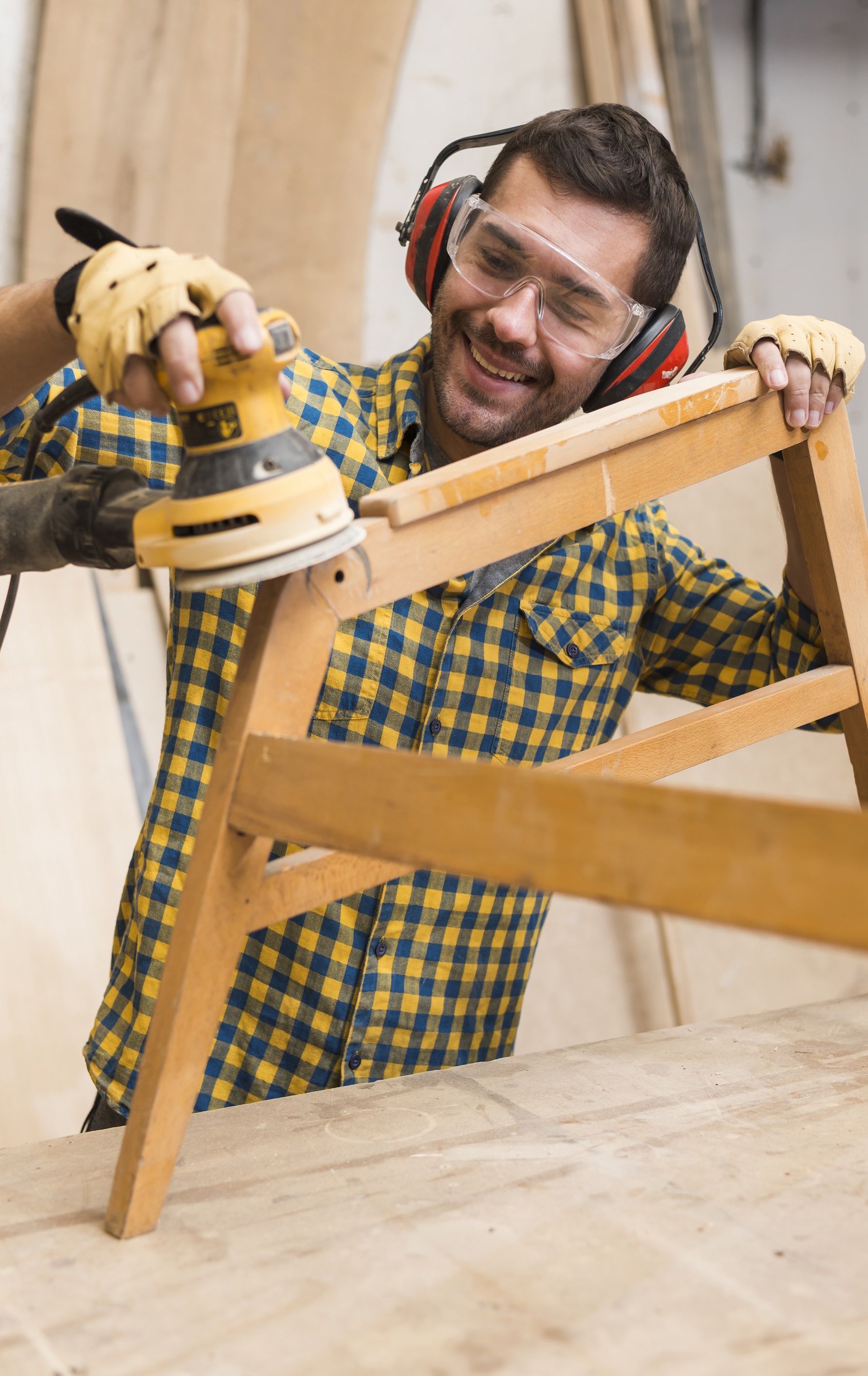 Close-up of a carpenter from Woodbine sanding the edges of a wooden chair to smooth